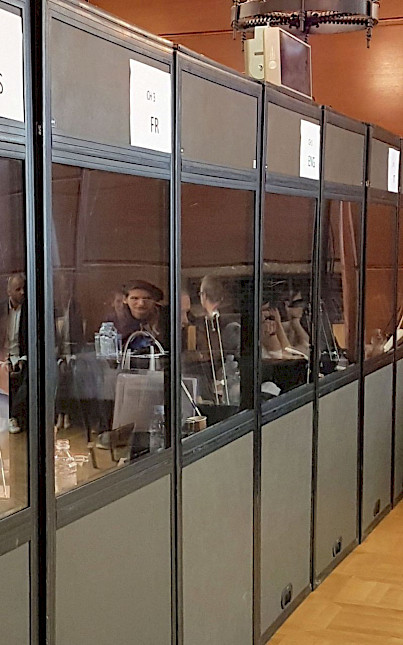 Several interpretation booths in a row with language and channel marks