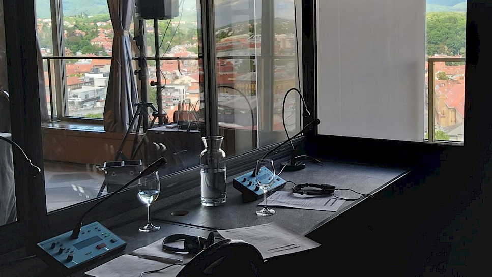 Water carafe on an interpreter's desk with conference hall view